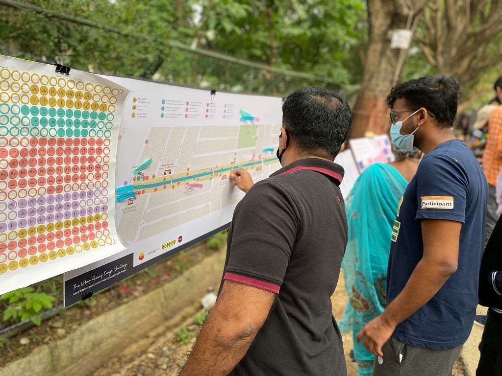 Two men registering their responses on a board attached to a park railing