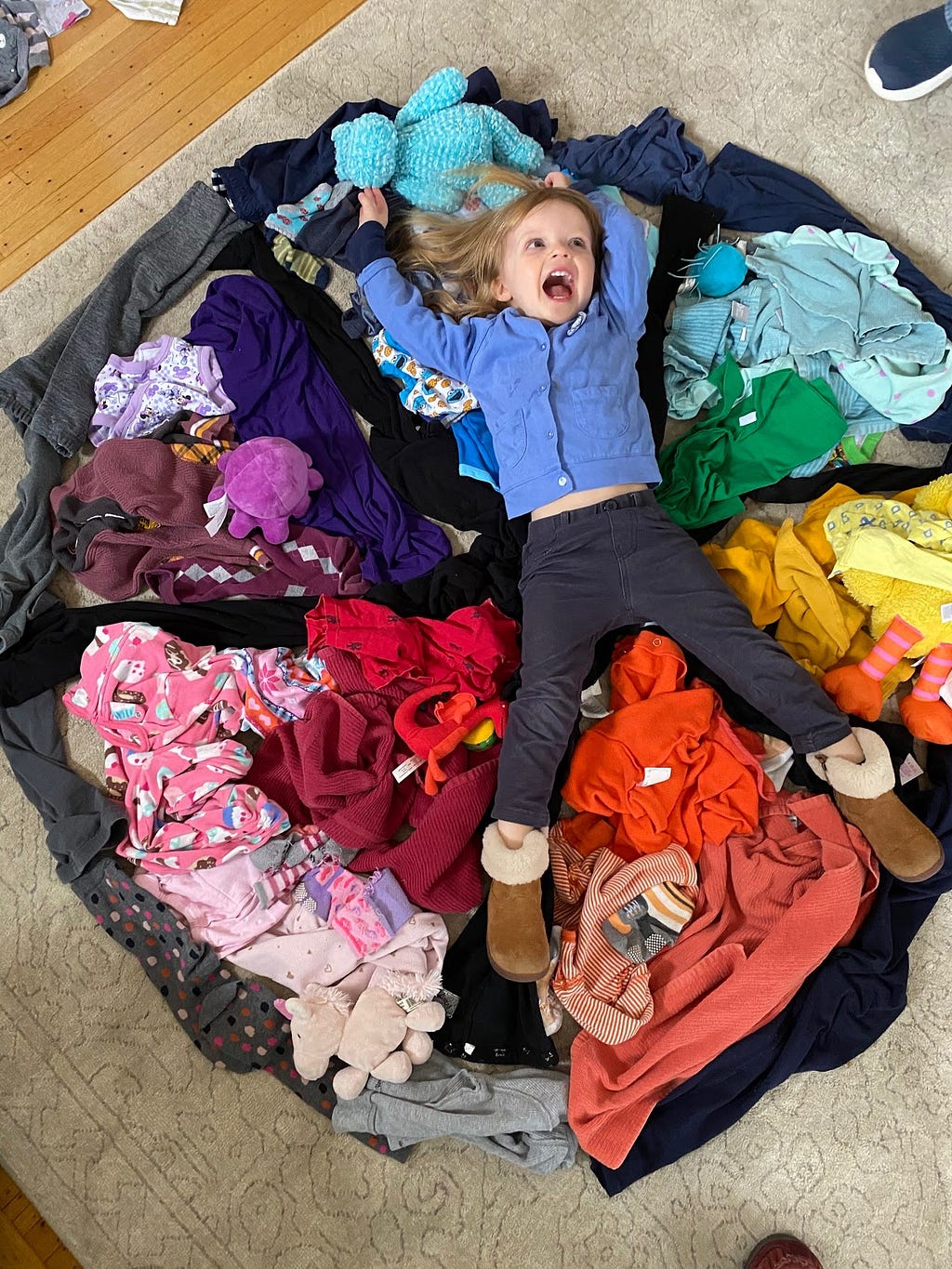 A child lies in a pile of laundry.