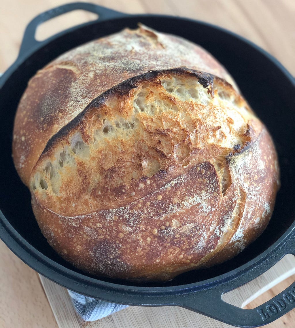 Perfect homemade artisan sourdough bread in a cast iron pan.