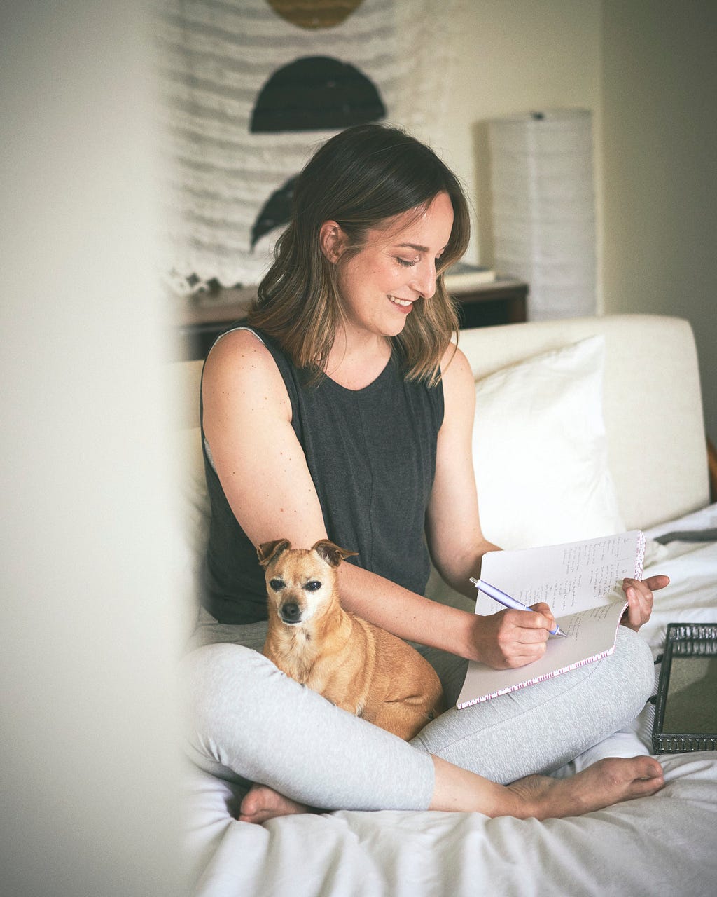 dani and her tan chihuahua bambi sitting on a bed