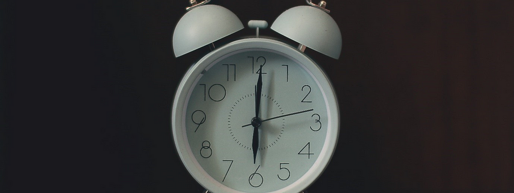 Photo of a white ring-bill alarm clock.