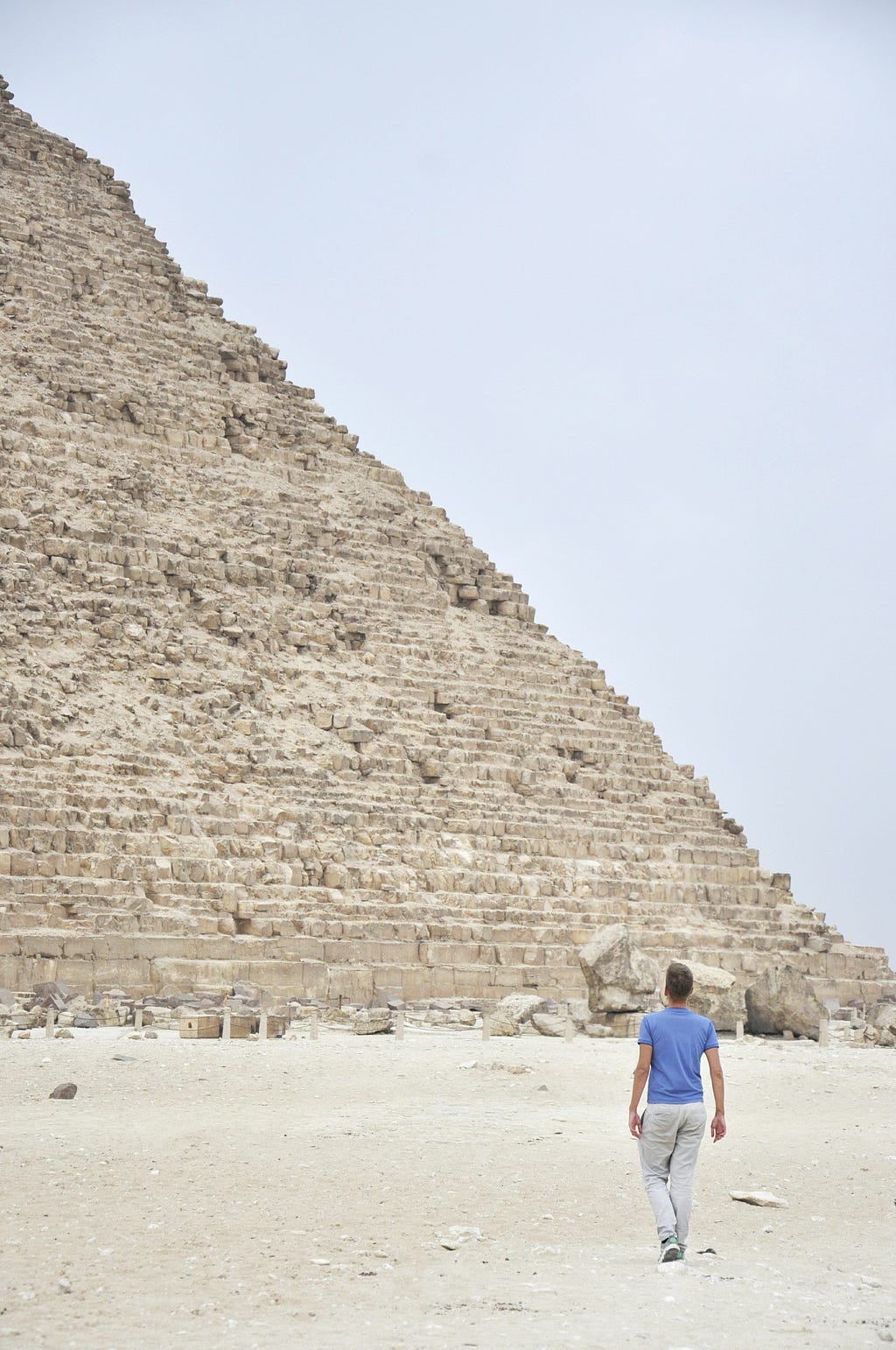 An ancient pyramid with a person walking toward it.