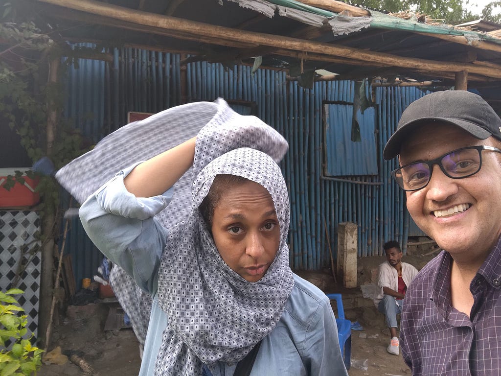 A woman who is adjusting her hijab and a man pose for a photo.
