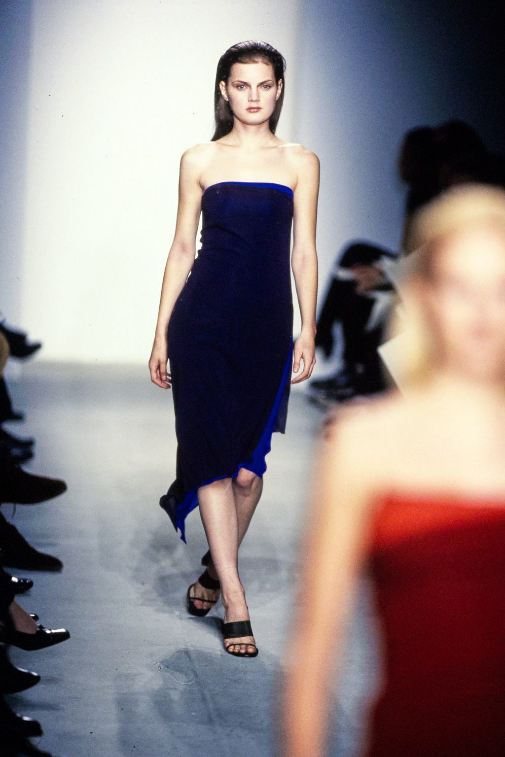 Guinevere Van Seenus modeling a navy blue tube dress on the runway.