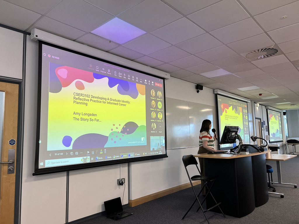 A Lecturer presenting in front of attendees.