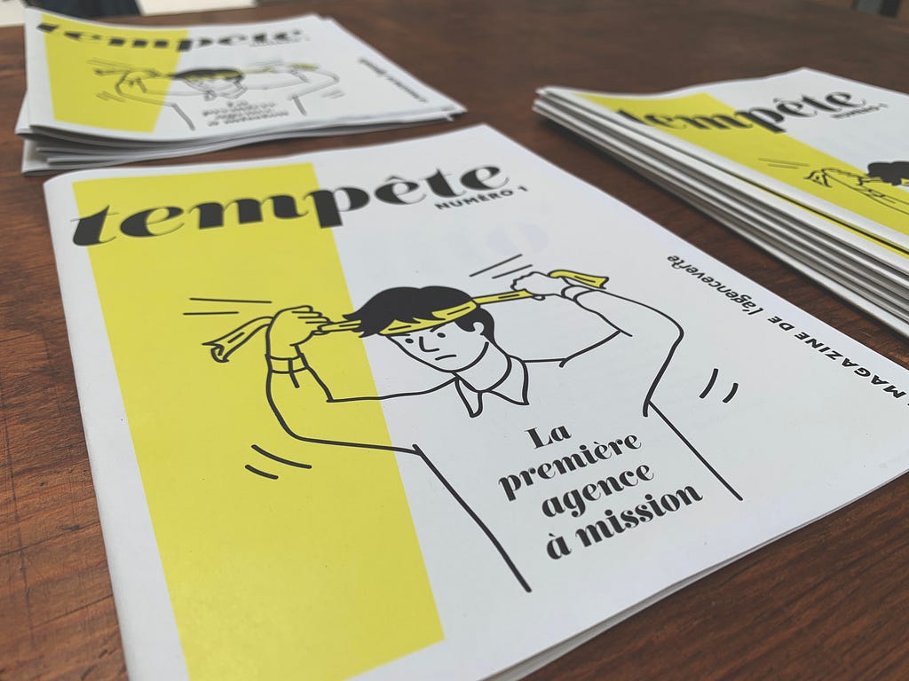 Photo du magazine Tempête sur une table en bois. Le personnage noue un foulard autour de sa tête et a l’air déterminé.