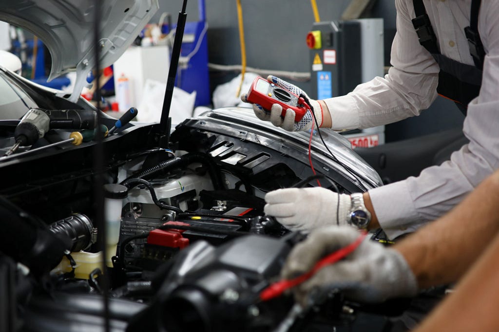 Auto Electrical Mechanic performing few test on a car