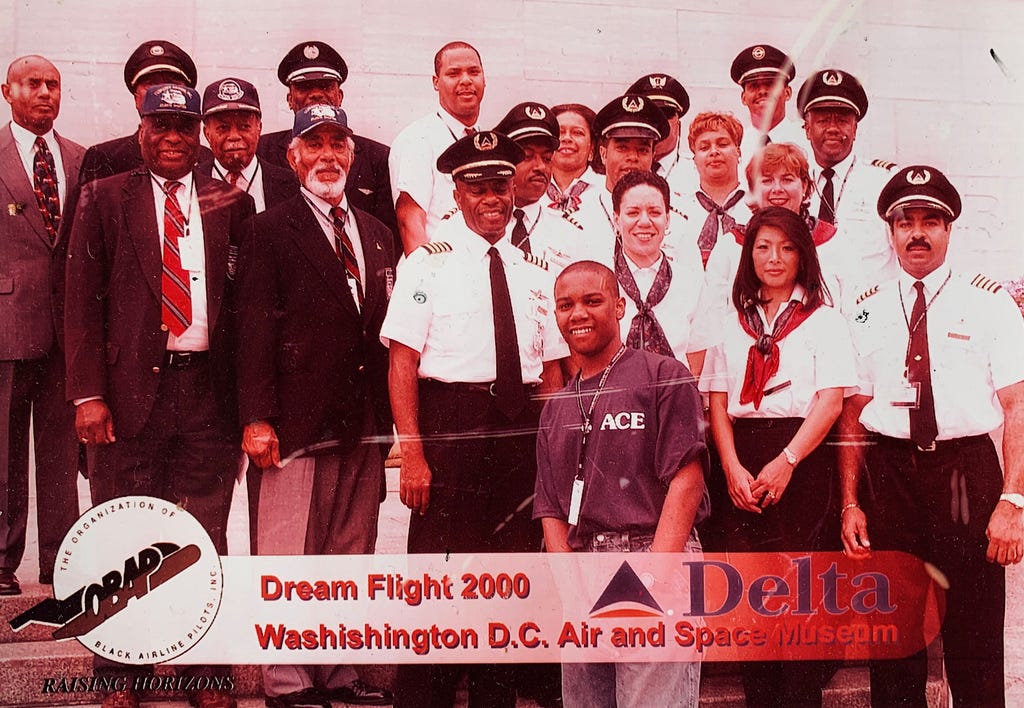 Biassou as a teen in 2000 posing with the air crew of the Dream Flight.