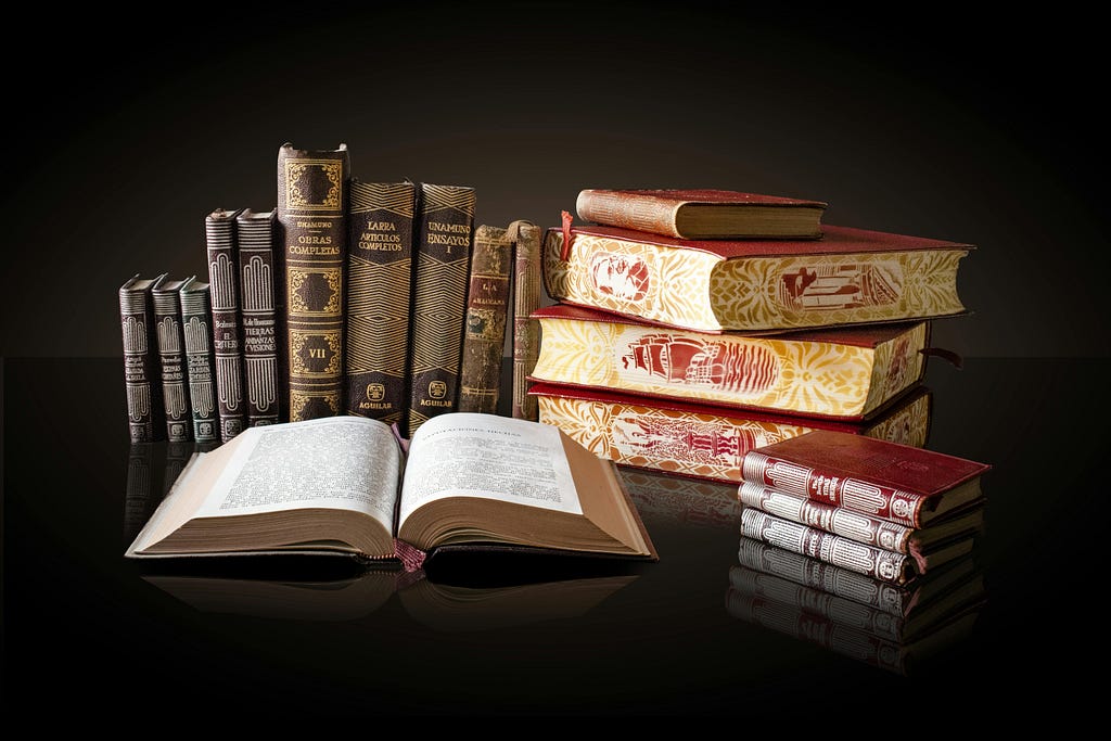 A nicely arranged collection of antique books against a black background.