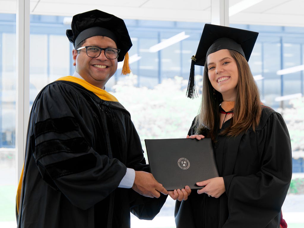 Interim Dean Anijo Mathew awarding a diploma to Monica Villazon San Martin