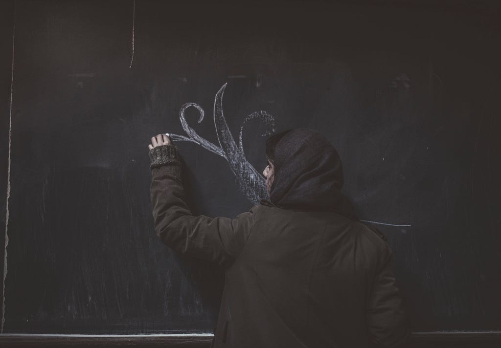 Melika, 20,  drawing on the blackboard after her Painting class. Tehran, January 2016. © Francesca Manolino / LUZ