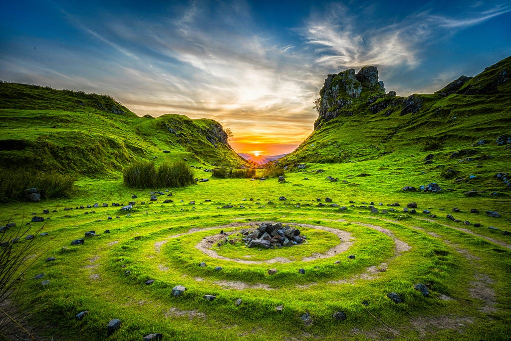 A photo of a field with concentric circles and rocks in the middle, at sunset