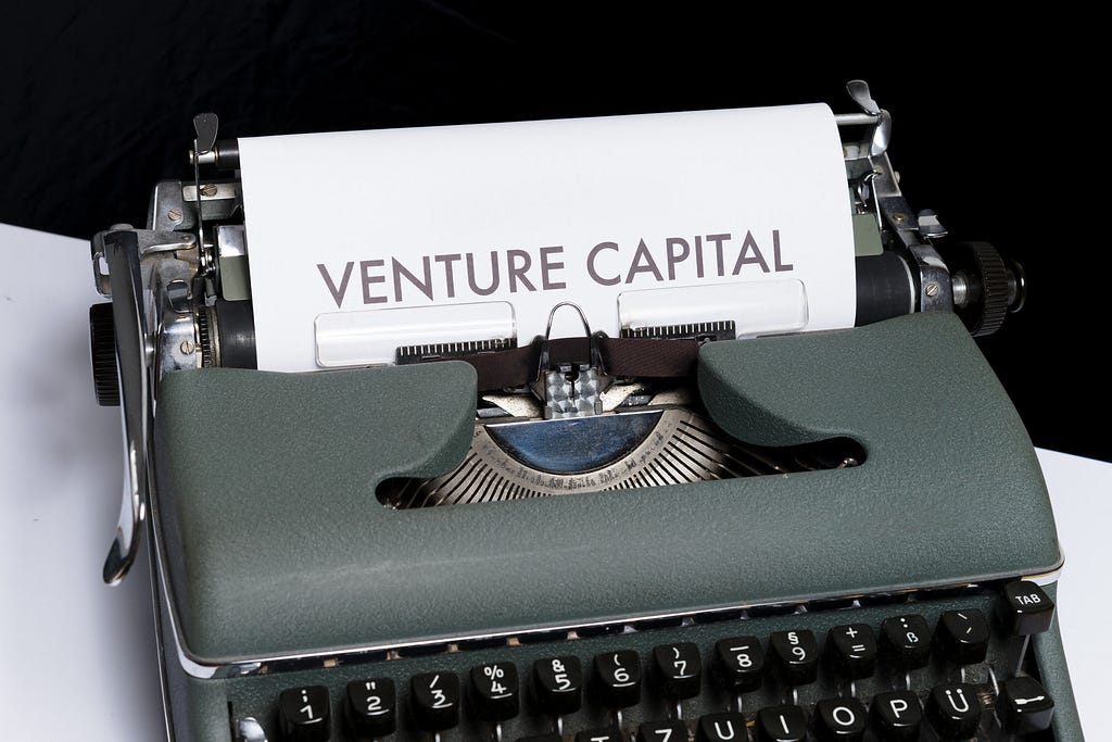 A photo of an old fashioned type writer that says “Venture Capital” on the page