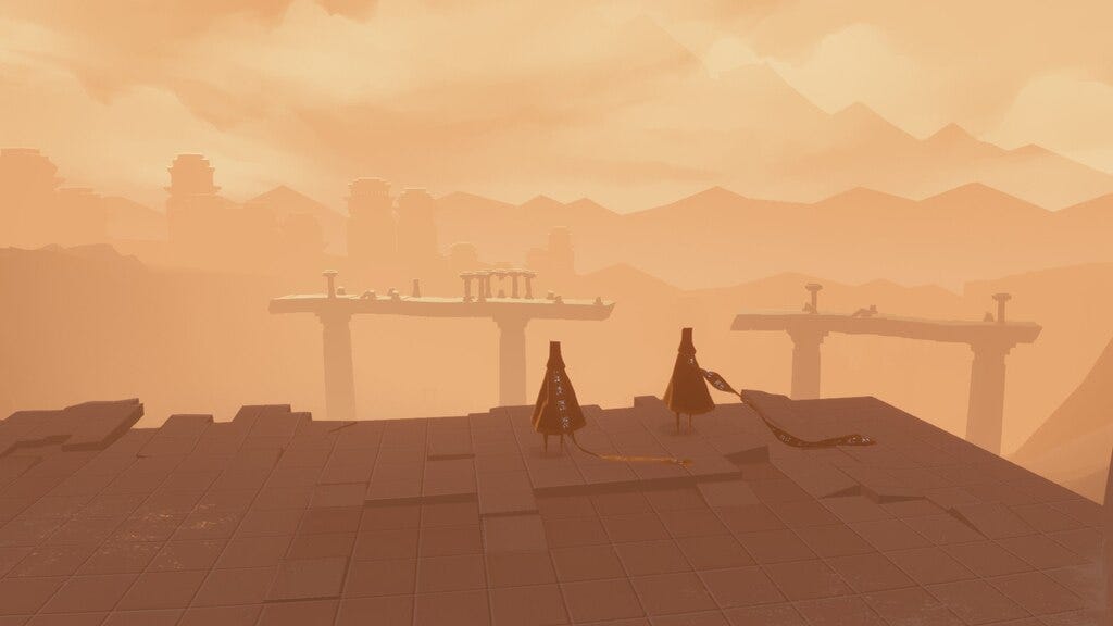 Screenshot from Journey. Two players stand on the edge of a road, overlooking the desert skyline.