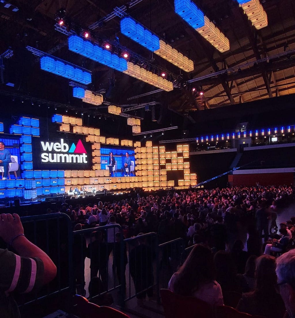 Imagem do palco principal do web summit Lisboa 2022 iluminado com as cores da bandeira da Ucrânia.