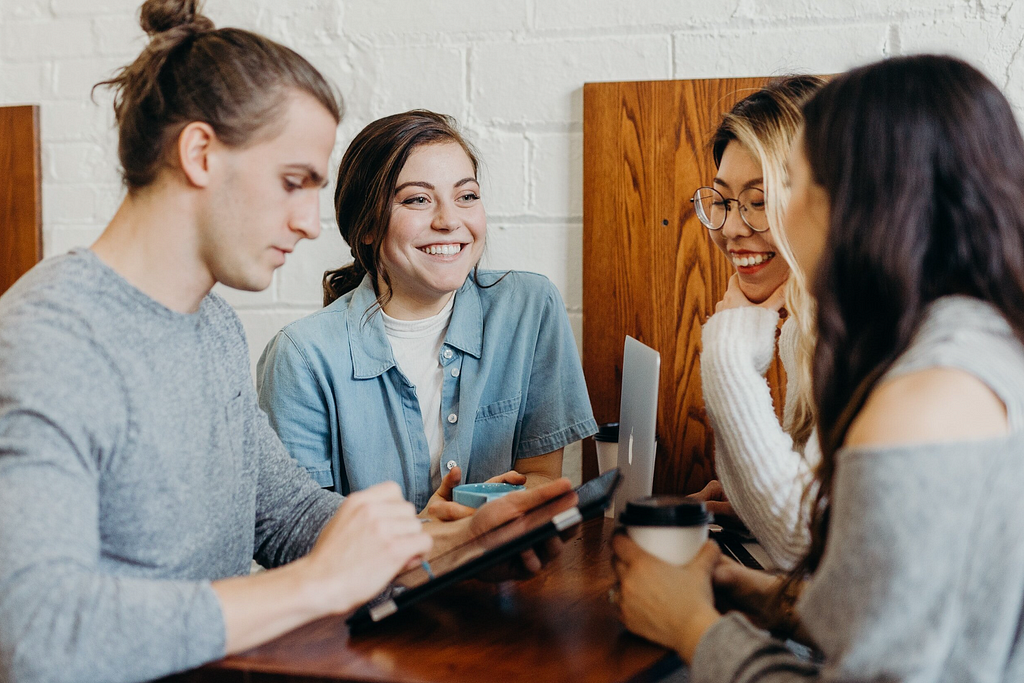 Four people sit and work on a website