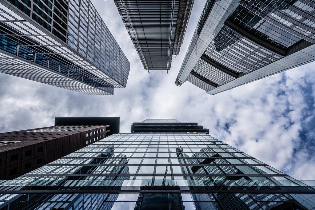 Photo of the sky from a place on the ground that is surrounded by skyscrapers.