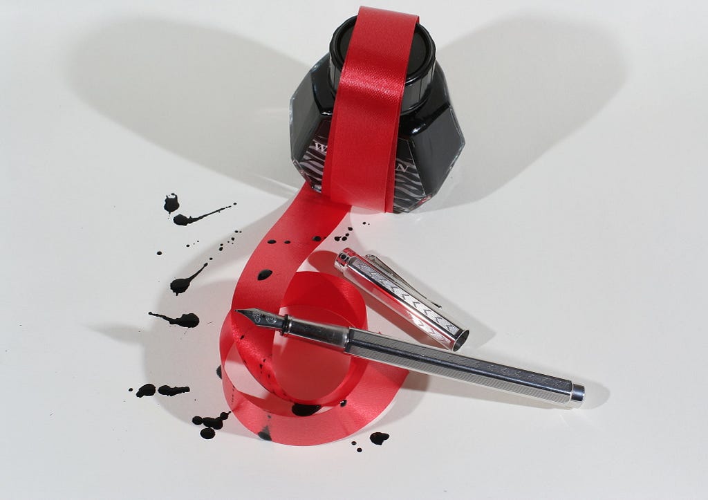 Red tape over ink jar and pin intended to denote bureaucracy