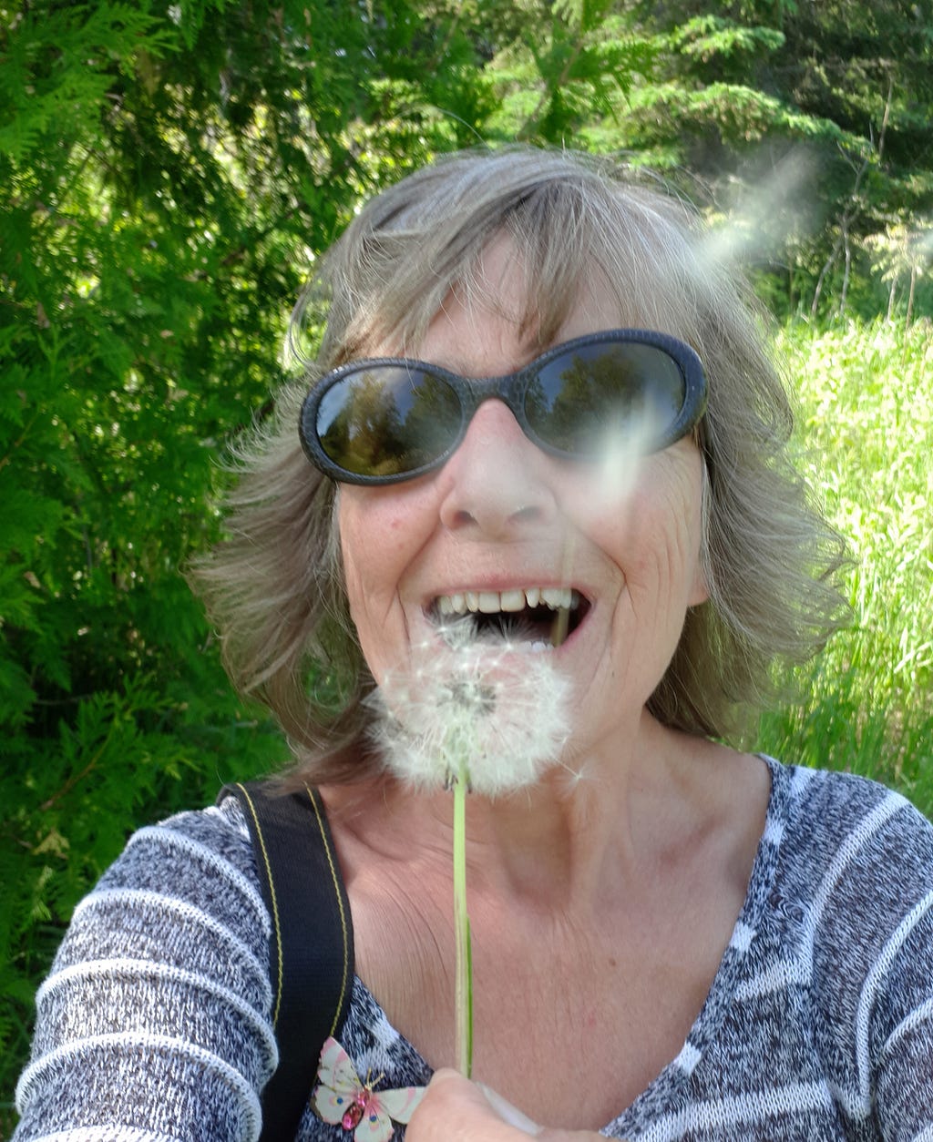 The author blowing a dandelion clock and making a wish. Image, Sheila Sharpe- Beasley