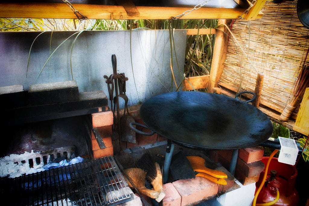 A closer shot of the big black tawa sitting on a gas paella burner