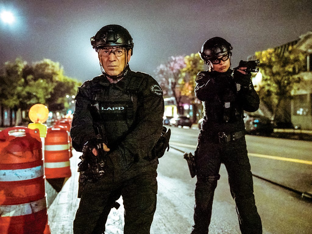 Two actors on a television set in SWAT gear.