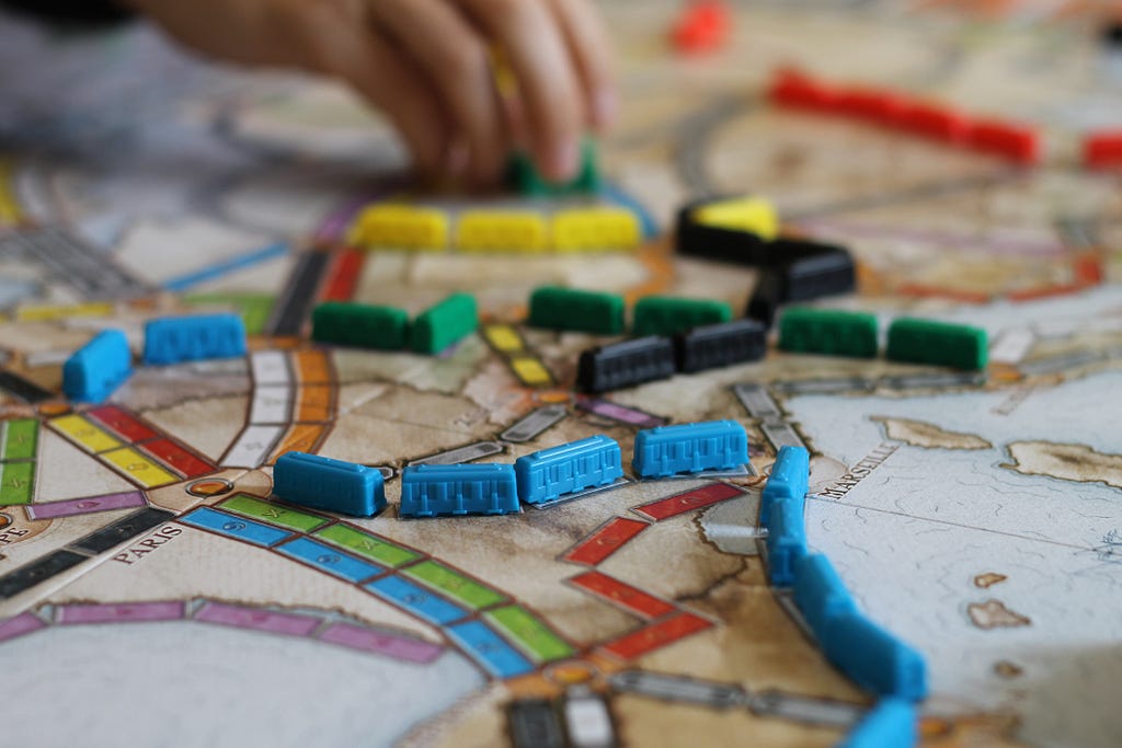 Board game map with train lines filled with tiny trains of multiple colors