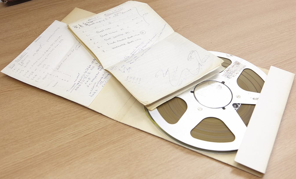 sound reel and handwritten notes and doodles on two sheets of paper and attached to the inside of the reel case from the Delia Derbyshire archive.