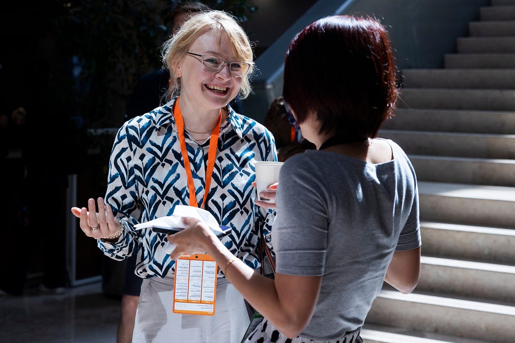 A speaker and an attendee speaking during a coffee break at UXLx 2025.