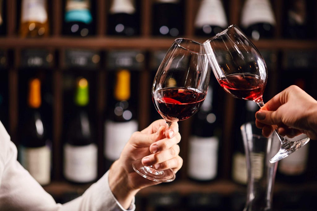 Two people making a toast of a glass of wine.