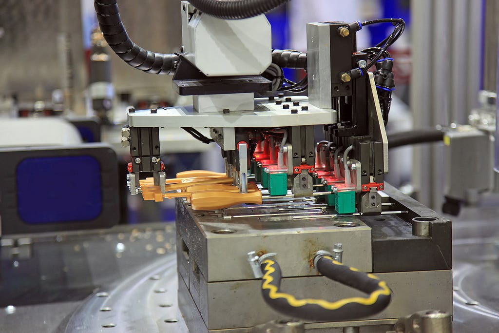 After the prototyping stage, injection molded screwdriver handles being separated from a custom steel mold