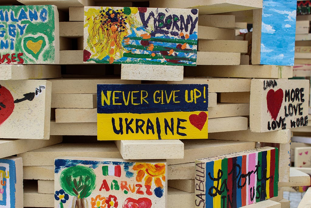 A sign that says ‘Never give up! Ukraine’ rests among other positive messages.