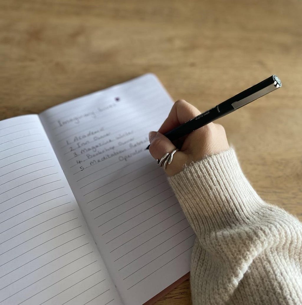White feminine hand writing in a journal.