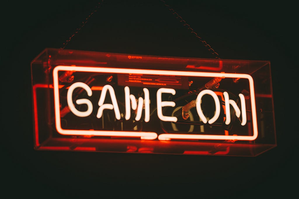 A neon sign glows in red with the words ‘Game On’.