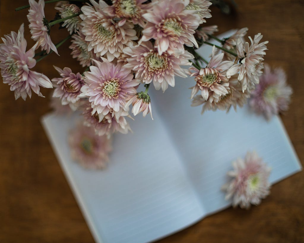 Flores sobre un cuaderno en blanco