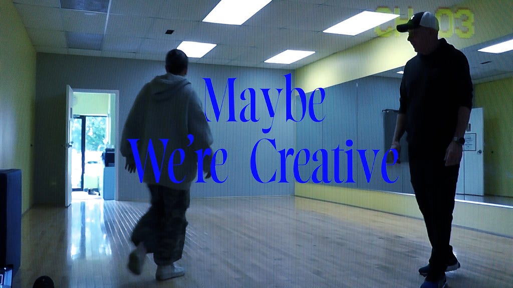 Film still of researcher and her dad in the dance studio with Maybe We’re Creative, the film title, in blue letters in the middle of the frame.