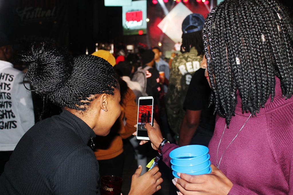 2 young black women looking at a mobile phone