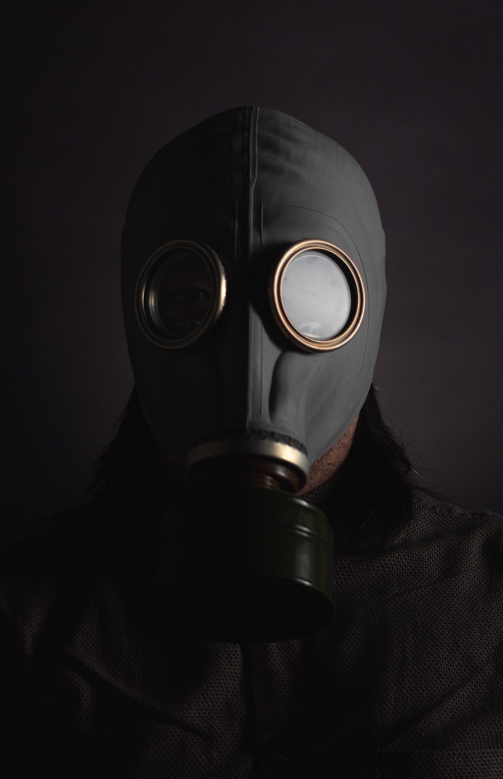 A person wearing a gas mask hiding his face