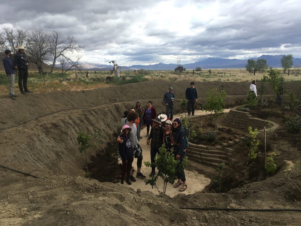 The SEED team gathers in a teardrop-shaped sunken rain garden that was constructed using natural local materials.