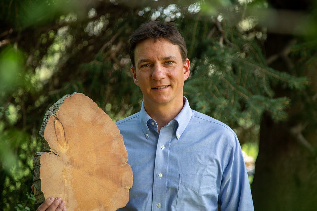 John Sakulich hold one of his tree stumps in his right hand