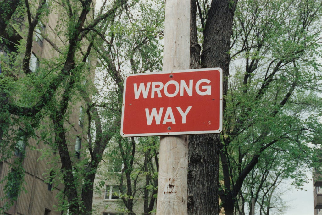 a red sign with white letters that reads “wrong way”