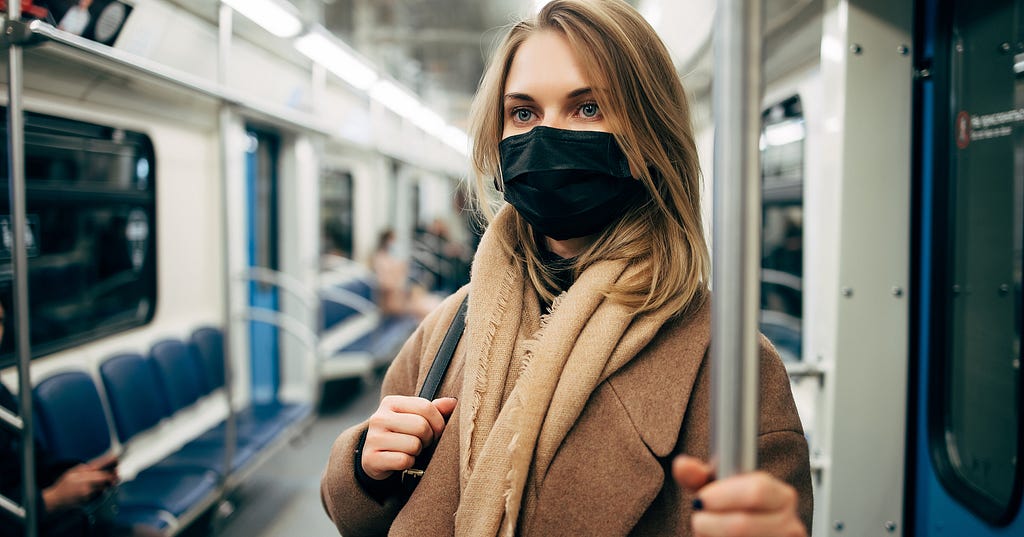 Covid-19 has fundamentally changed everything about how we work, including our commute. Image of a woman wearing a face mask.