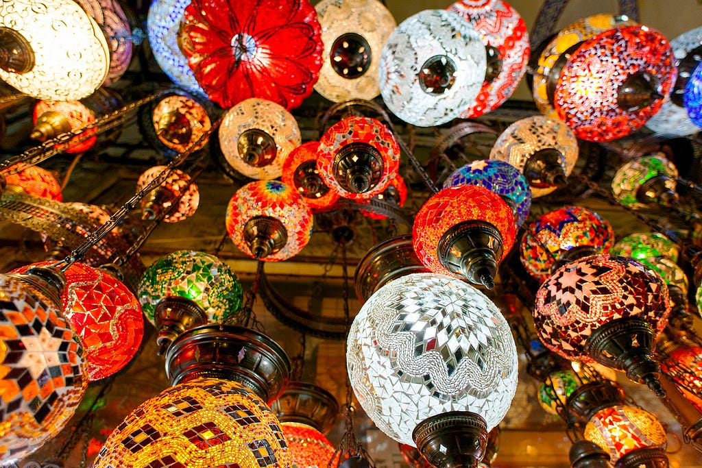 looking up at multiple colorful turkish style lamps