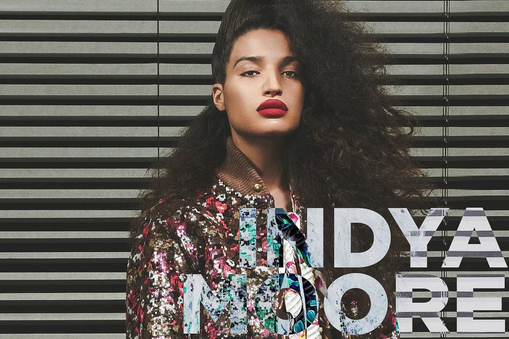 A photograph of Indya Moore, looking at the camera with a sultry expression.