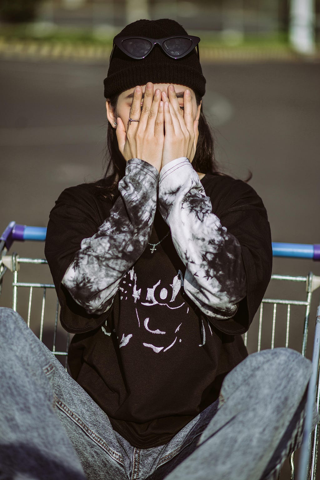 Image of a girl covering her face while posing for the photoshoot of the streetwear brand