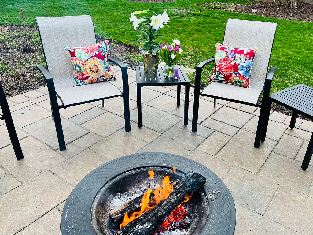 Author patio on Easter, tulips and lilies displayed before a firepit.
