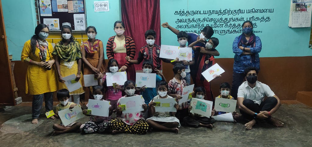 A group picture with the children wearing masks and holding their mask superhero drawings