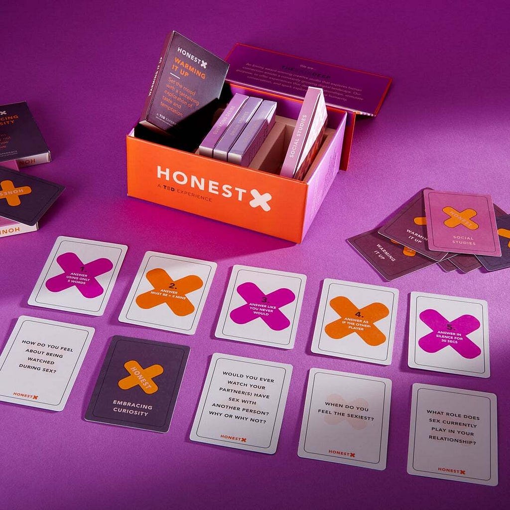 The complete Product of Honest X is laid out with the box, the question cards, and the 5 formats for dynamic gameplay.