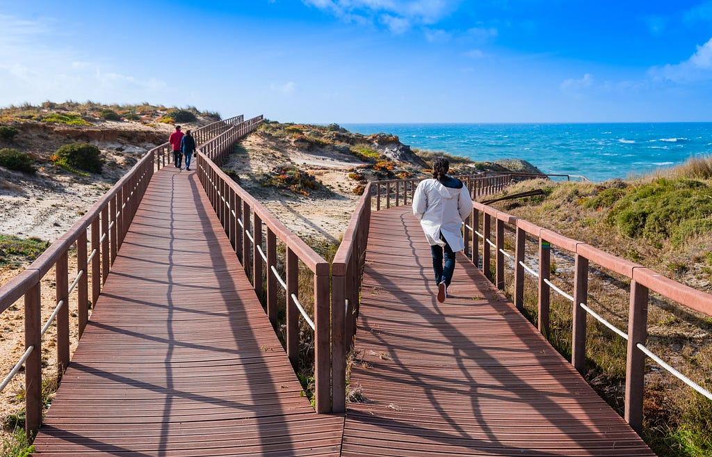 Two different wooden paths heading in different directions to the same destination
