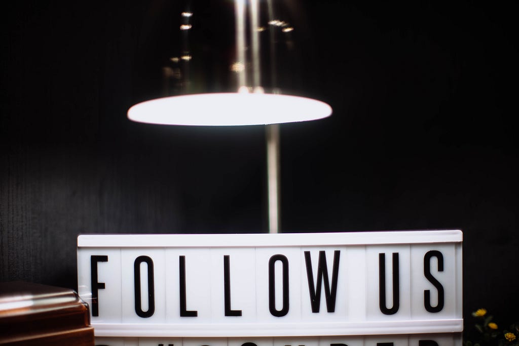 ‘Follow us’ written on a board