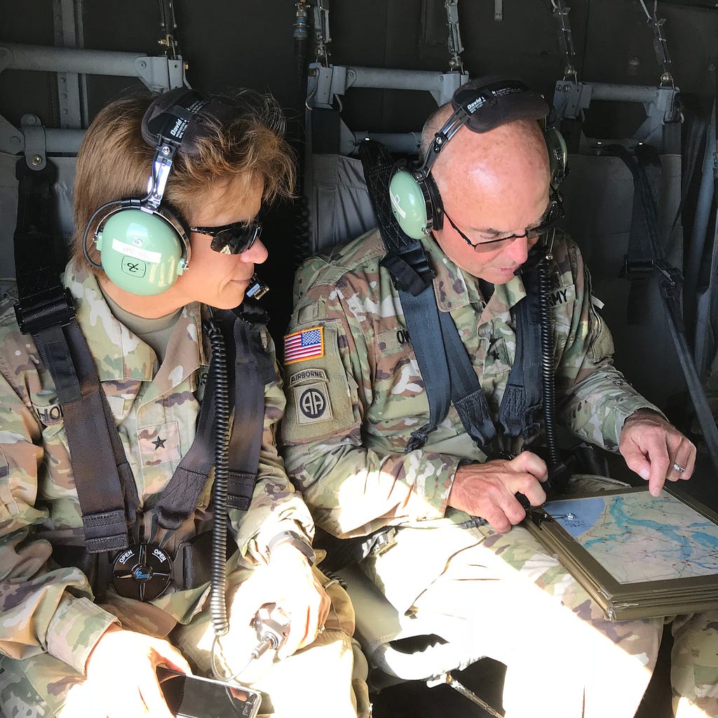 Two Army soldiers (including the author) in a helicopter reviewing maps as they fly over flooded parts of South Carolina following Hurricane Florence in 2018.